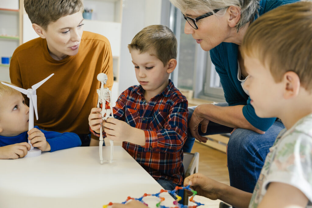 boy playing with a skeleton and two kids and two women are surrounding him