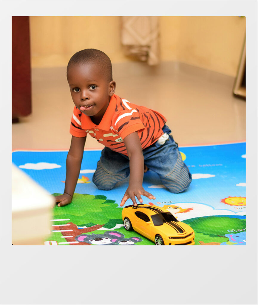 kid playing with a yellow car on the floor