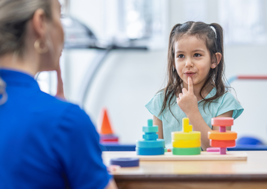 woman and kid touching their bottom lip with toys by them