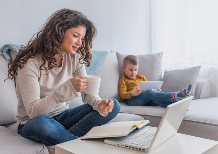 Mom researching on computer with child in background